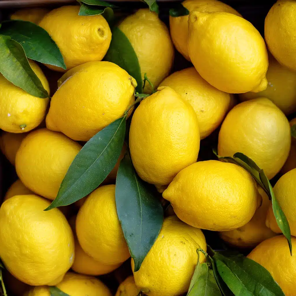 salt-pickled-lemons Fresh yellow lemons with green leaves stacked at a market, perfect for making salt pickled lemons.